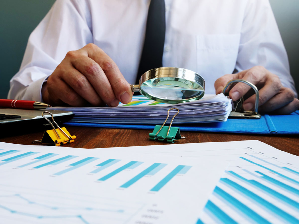 An Auditor Reviewing Documents with a Magnifying Glass